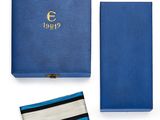 une boîte bleue avec une cravate rayée et un portefeuille bleu
