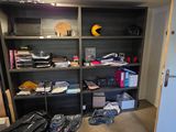 a room with a bunch of luggage and a book shelf