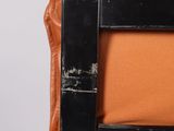 an orange couch with a black metal frame and a brown cushion