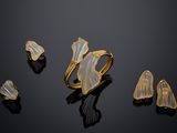 three pieces of gold jewelry on a black surface