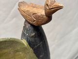 a wooden bird sitting on top of an egg