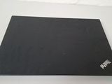 the laptop is sitting on a table with a white wall behind it