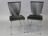 pair of black chairs with metal legs and a black seat