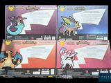 four different pokemon trading cards are on display in a box