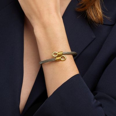 une femme portant un blazer noir et un bracelet en or