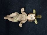 a small doll of a baby laying on a black surface