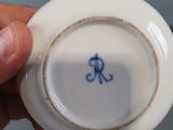 a person holding a small white plate with a blue design on it