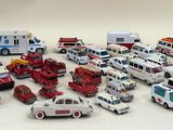 a lot of toy cars and trucks that are on the table