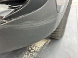 a close up of a car ' s front bumper with mud on it