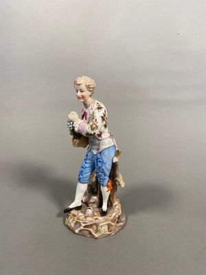 a figurine of a man with a basket of flowers