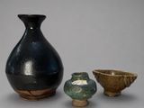 trois petits vases posés l'un à côté de l'autre sur une table