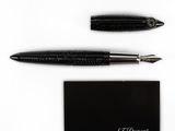 the pen is laying on top of the business card next to the pen
