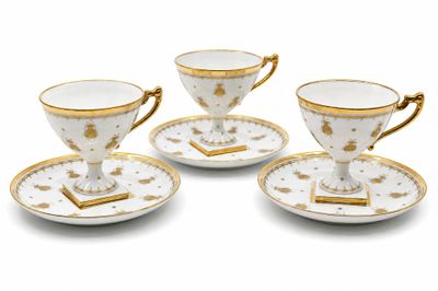 trois tasses et soucoupes sont posées sur une surface blanche