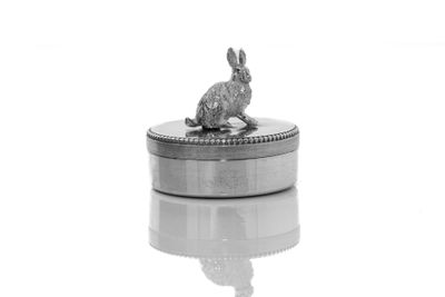 un lapin en argent posé sur une boîte en argent
