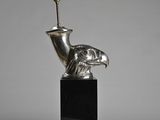 an image of a silver sculpture of a bird on a black base