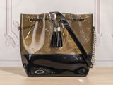 black and gold handbag with tassels on a wooden table