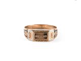 a close up of a gold ring with a sign on it
