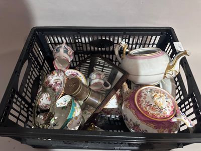 un panier noir rempli de théières et de tasses à thé