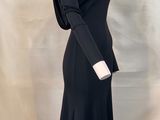 the dress is black and has long sleeves and a long skirt