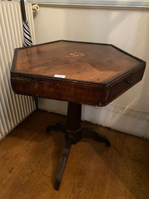 a small table with a wooden top on a hard wood floor