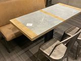 une table avec un banc et deux chaises dans une pièce