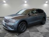 un SUV Volkswagen gris garé dans un garage au sol carrelé
