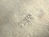 a close up of a piece of metal with the word pioneers on it