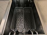 two large fryers in the middle of a stainless steel sink