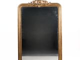 une image d'un miroir encadré d'or sur un mur blanc