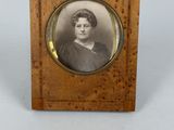 an old photo of a woman in a black dress in a wooden frame