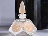 a bottle of perfume next to a bottle of perfume on a table