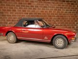 a red convertible car parked in front of a brick wall