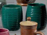 de nombreuses tasses de différentes couleurs alignées les unes à côté des autres sur une table