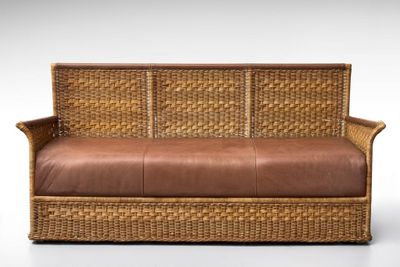 an image of a wicker couch with a brown leather cushion