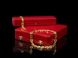 two red suitcases with chains on them on a black surface