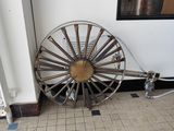 une grande roue métallique posée au sol dans une pièce