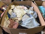 une boîte en carton remplie de vêtements dans une pièce