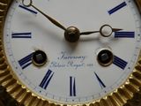 une horloge en or avec des chiffres romains sur le cadran