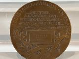 a bronze medal with a picture of a bird on it