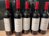 six bouteilles de vin rouge sont alignées sur une table