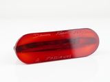 a close up of a red pill on a white surface