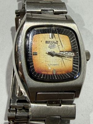 a close up of a watch on a metal bracelet