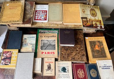 de nombreux livres posés sur une table, avec un miroir en arrière-plan