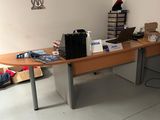 une photo d'un bureau dans une pièce où il y a beaucoup d'objets posés dessus
