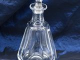 a clear glass bottle with a stopper on a blue cloth