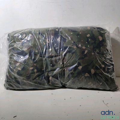 un sac en tissu camouflage posé sur une surface blanche