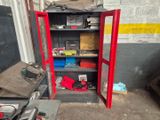 une armoire rouge posée dans un garage, sur laquelle se trouvent des outils