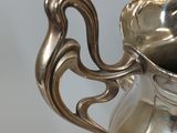 a silver vase that is sitting on a table