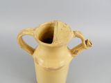 a yellow vase that has a handle on it
