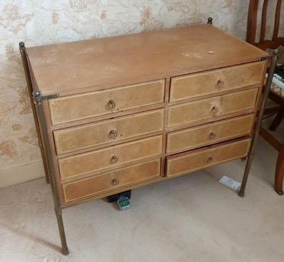 une commode et une chaise en bois dans une pièce dont l'un des murs est tapissé